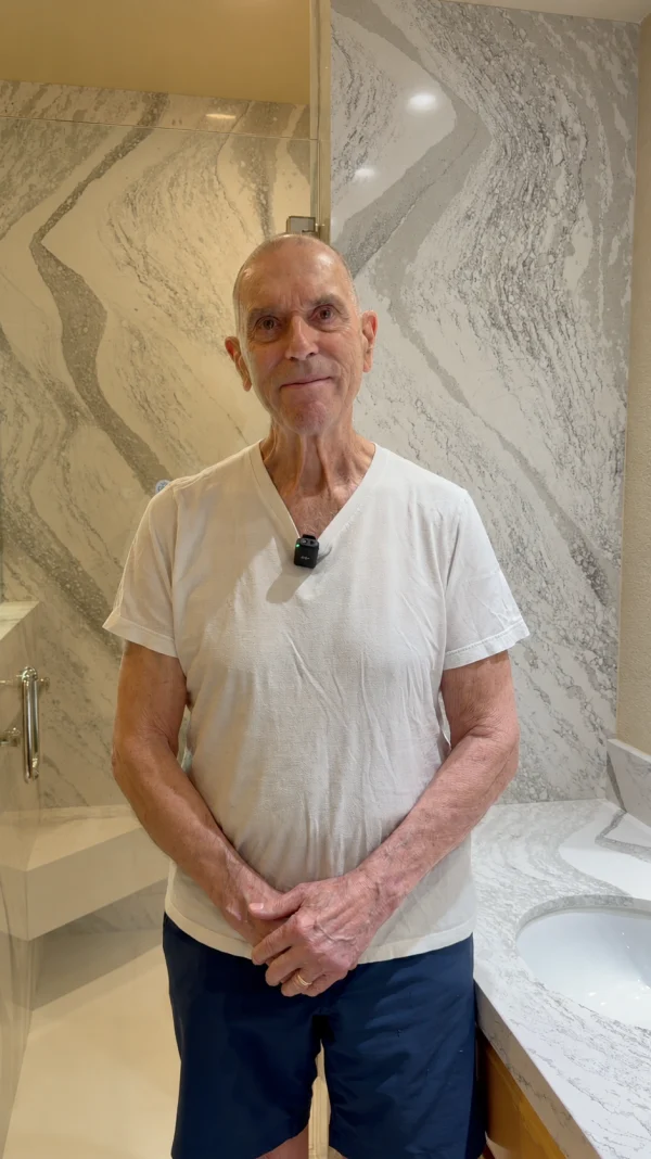 Homeowner standing in a bathroom with marble-look walls