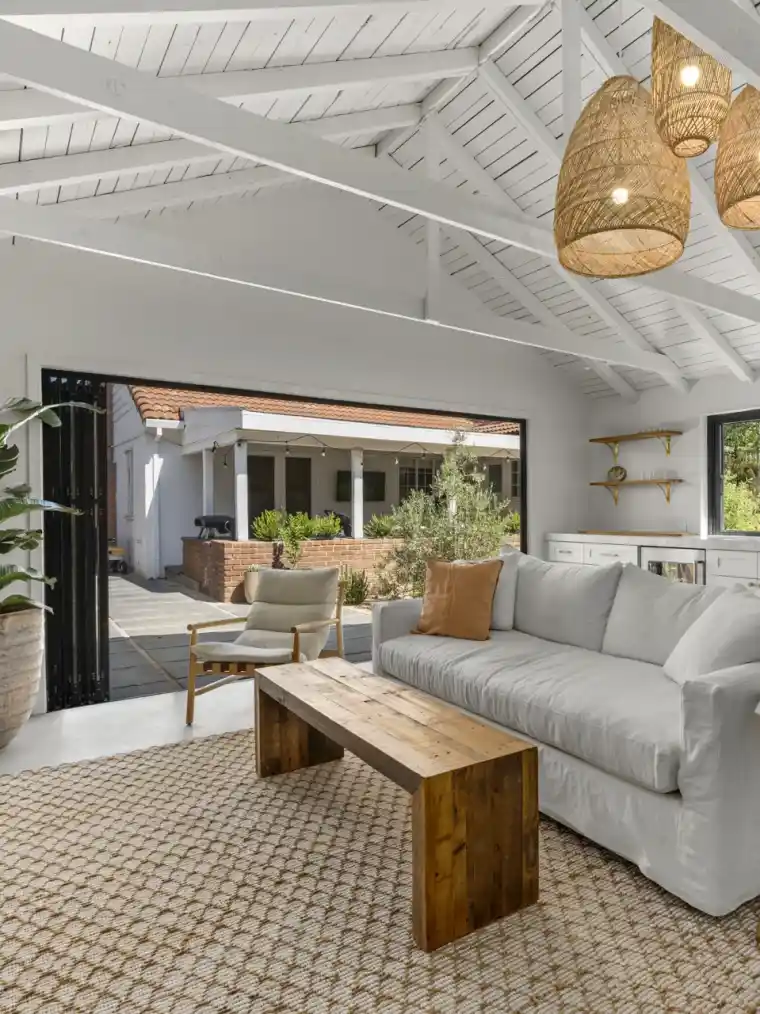 A garage converted into a living space with a vaulted white ceiling