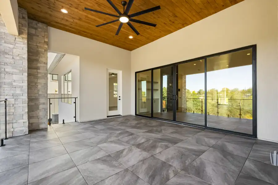 A black-frame sliding glass door opening onto a covered patio