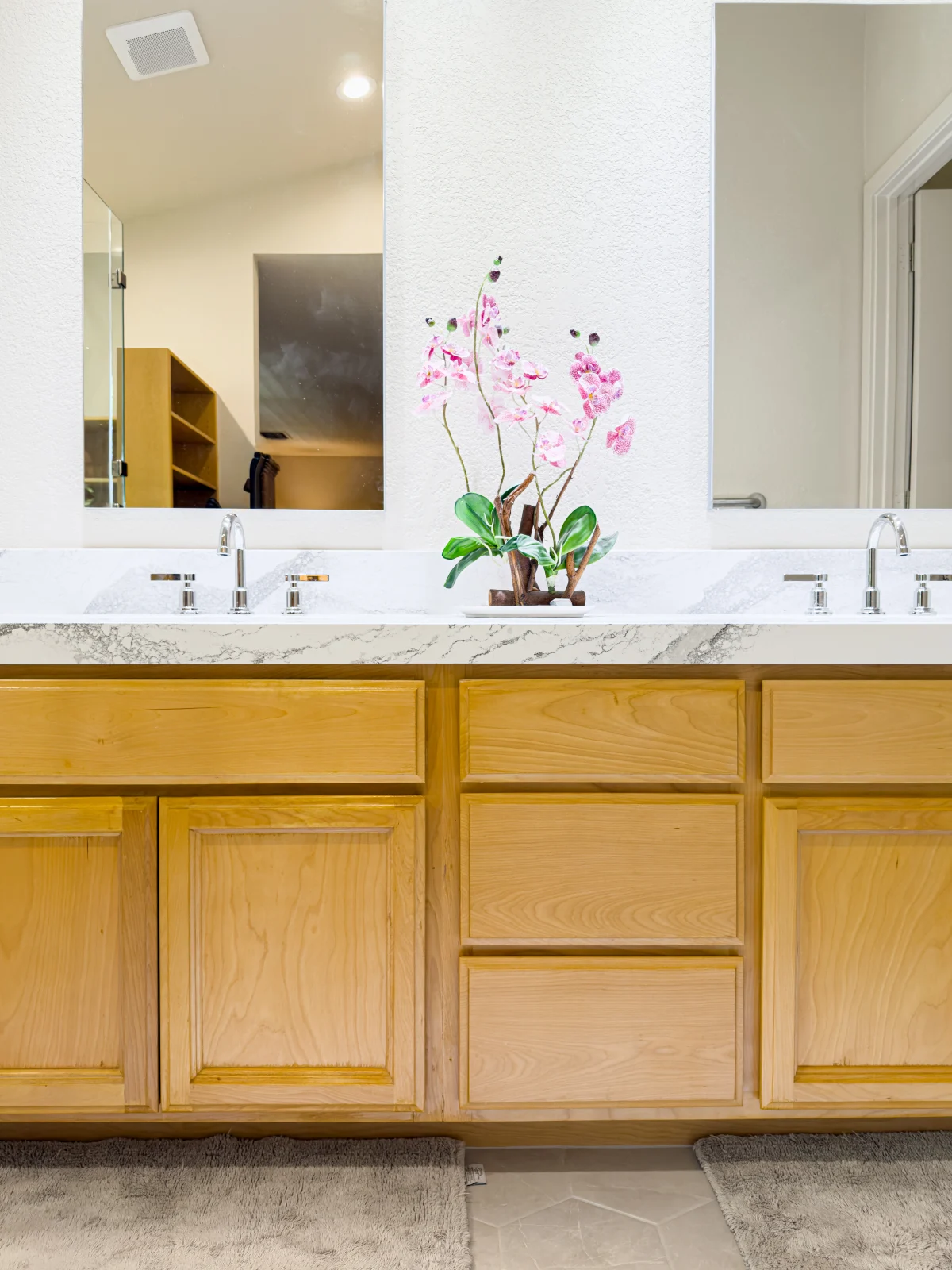 Bathroom vanity with light wood cabinets and two sinks
